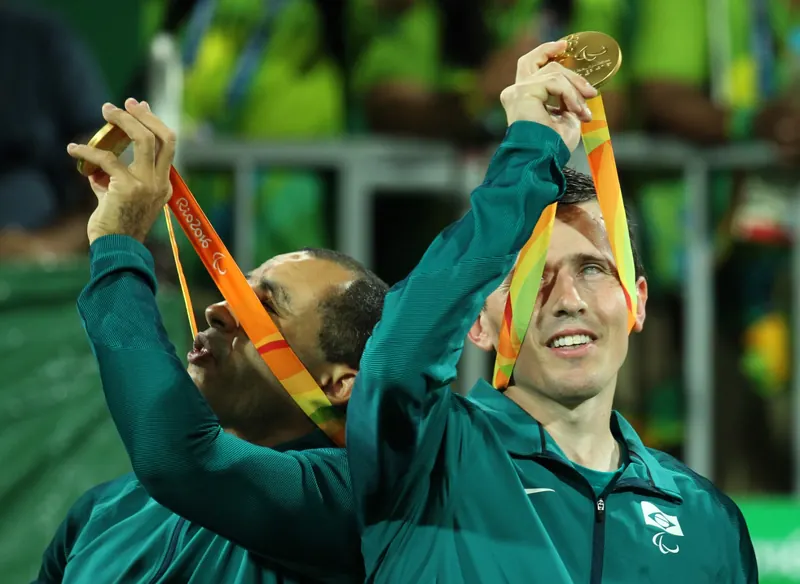 Ricardinho, com o casaco verde da Seleção Brasileira erguendo sua medalha de ouro dos Jogos Paralímpicos Rio 2016.